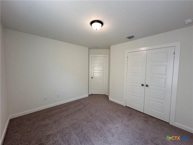 unfurnished bedroom featuring visible vents, a textured ceiling, a closet, carpet floors, and baseboards