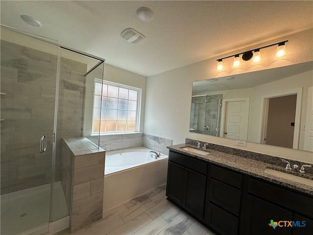 bathroom with a sink, a garden tub, double vanity, and a shower stall