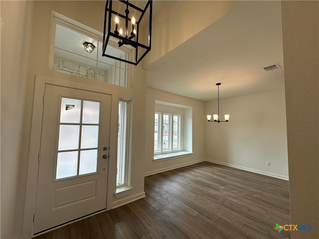 entrance foyer with visible vents, baseboards, dark wood finished floors, and a chandelier