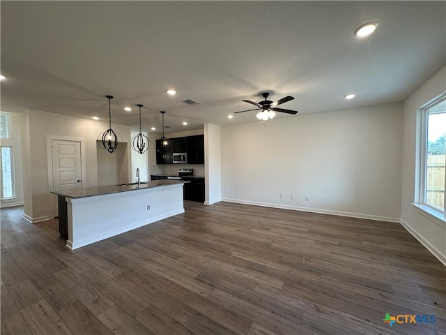 kitchen featuring dark wood-style floors, a center island with sink, visible vents, recessed lighting, and appliances with stainless steel finishes