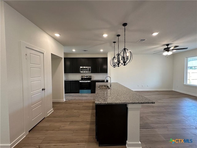 kitchen featuring wood finished floors, visible vents, a sink, appliances with stainless steel finishes, and dark cabinets