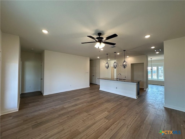 unfurnished living room featuring dark wood-type flooring, recessed lighting, a ceiling fan, and baseboards