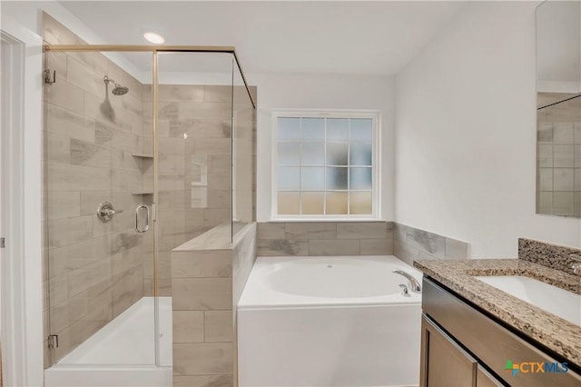 full bath featuring a shower stall, a garden tub, and vanity