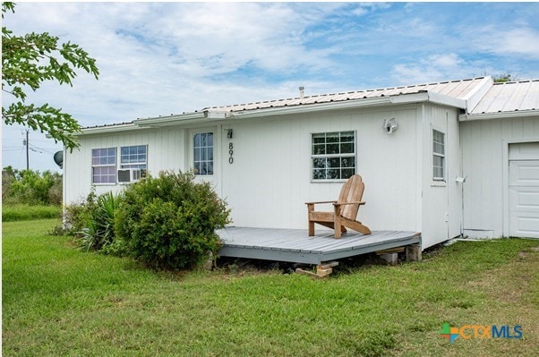 890 N Quail Run Ave, Port Lavaca, TX 77979 - back of property featuring a deck, a lawn, and metal roof