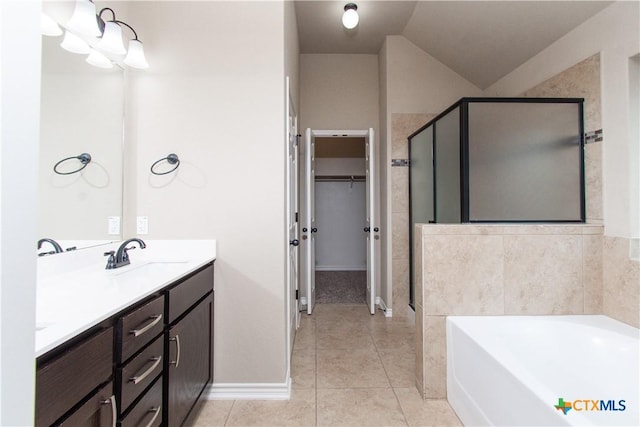 bathroom with a sink, tile patterned flooring, a shower stall, and a spacious closet