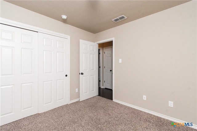 unfurnished bedroom with carpet floors, baseboards, a closet, and visible vents