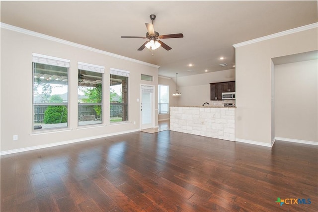 unfurnished living room featuring crown molding, dark wood-style flooring, ceiling fan, and baseboards
