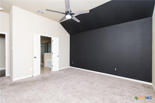 unfurnished bedroom featuring ensuite bath, carpet, baseboards, lofted ceiling, and visible vents