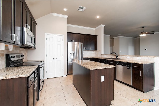kitchen featuring decorative backsplash, visible vents, appliances with stainless steel finishes, a center island, and a peninsula