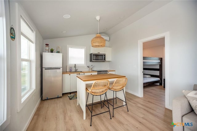 1707 N Ocean Dr, Port Lavaca, TX 77979 - kitchen featuring stainless steel appliances, wooden counters, light wood-style flooring, a sink, and lofted ceiling