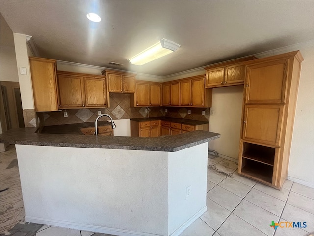 kitchen with backsplash, kitchen peninsula, and crown molding