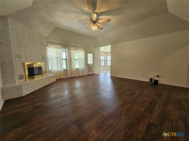 unfurnished living room featuring dark hardwood / wood-style flooring, a brick fireplace, a textured ceiling, ceiling fan, and lofted ceiling