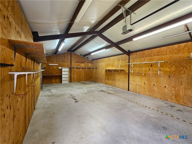 garage featuring a garage door opener and wood walls