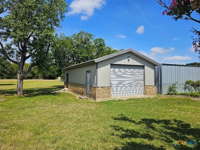 view of outdoor structure featuring a yard and a garage