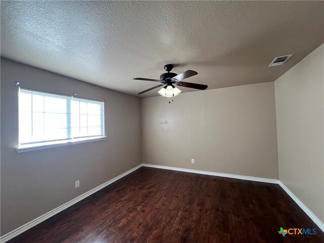 unfurnished room featuring a textured ceiling, dark hardwood / wood-style flooring, and ceiling fan