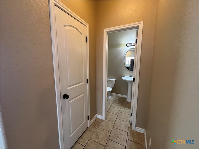 hall with light tile patterned flooring and sink