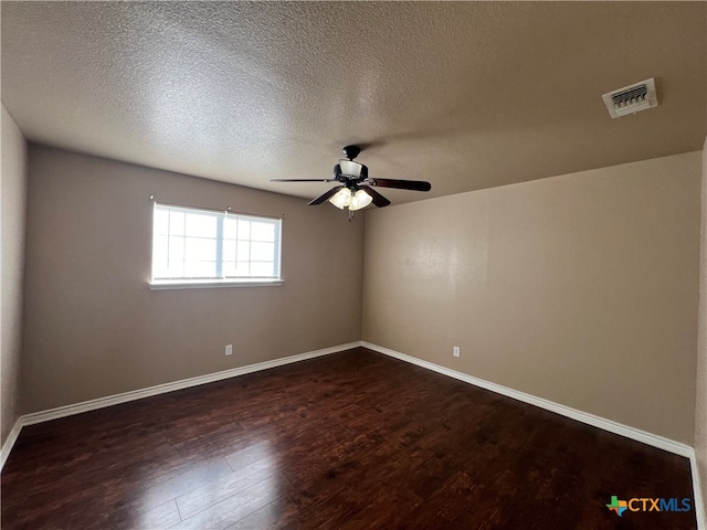 empty room featuring ceiling fan, a textured ceiling, and dark hardwood / wood-style floors