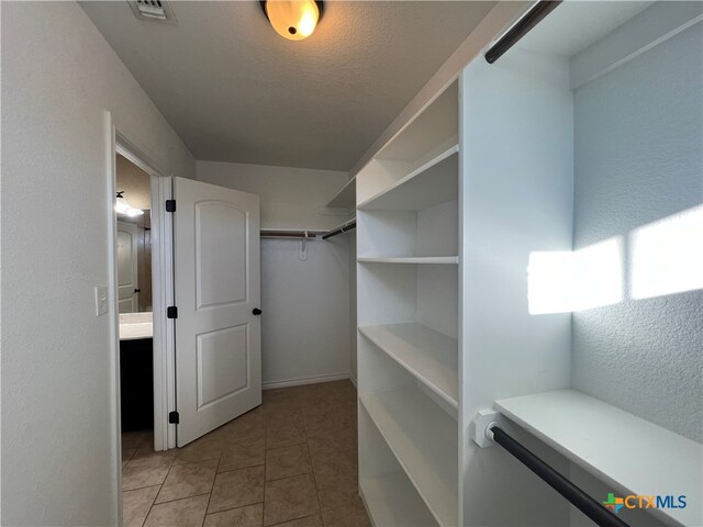 walk in closet featuring light tile patterned flooring