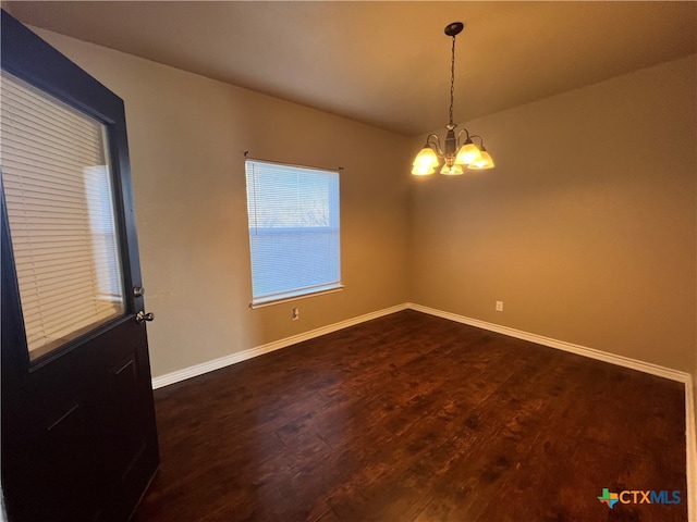 unfurnished room with dark wood-type flooring and a chandelier