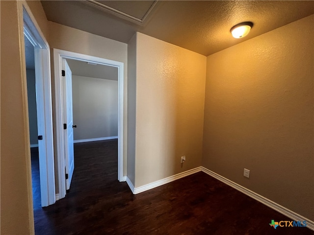 hall with dark hardwood / wood-style flooring and a textured ceiling