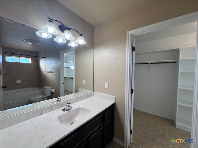 full bathroom with tile patterned flooring, vanity, tiled shower / bath combo, and toilet