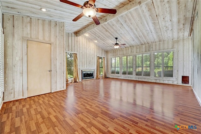 210 Oak Creek Cir, Luling, TX 78648 - unfurnished living room with a ceiling fan, wood finished floors, a glass covered fireplace, wooden ceiling, and wood walls