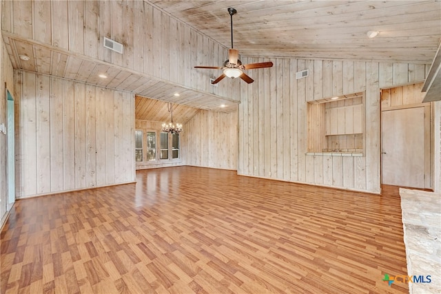210 Oak Creek Cir, Luling, TX 78648 - unfurnished living room featuring wood finished floors, a chandelier, ceiling fan, vaulted ceiling, and wooden walls