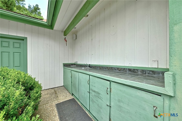 210 Oak Creek Cir, Luling, TX 78648 - kitchen featuring tile counters and wooden walls
