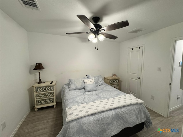 bedroom with ceiling fan and dark wood-type flooring