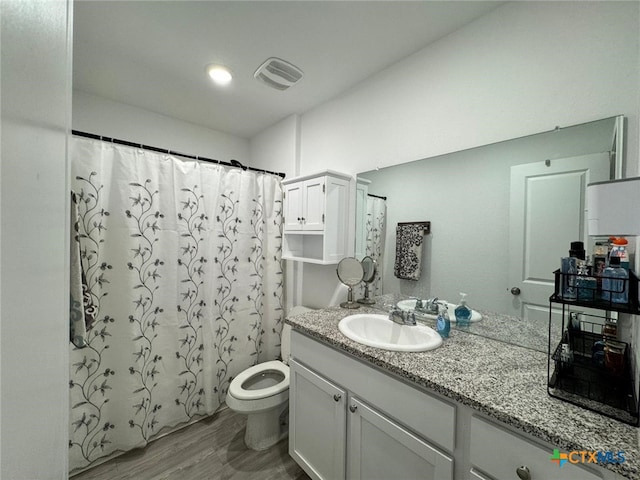 bathroom featuring a shower with curtain, vanity, hardwood / wood-style flooring, and toilet