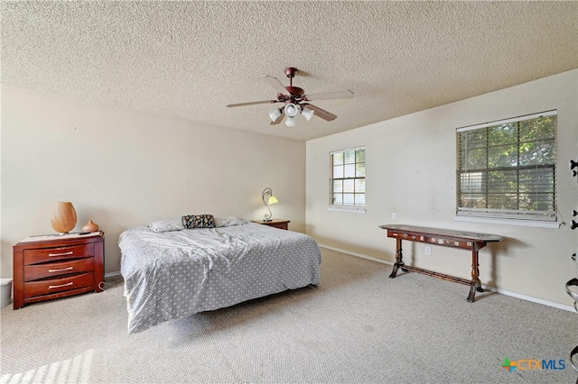 carpeted bedroom featuring ceiling fan and a textured ceiling