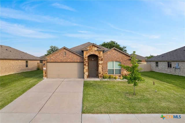 206 Danielle Dr, Killeen, TX 76542 - view of front facade with a garage, driveway, stone siding, and a front lawn