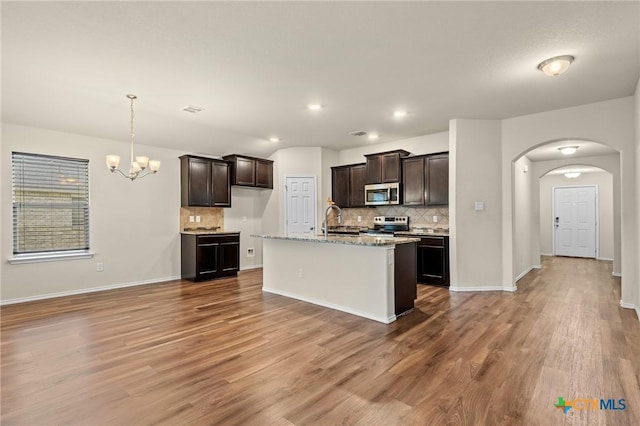 206 Danielle Dr, Killeen, TX 76542 - kitchen featuring stainless steel appliances, arched walkways, backsplash, dark brown cabinetry, and recessed lighting