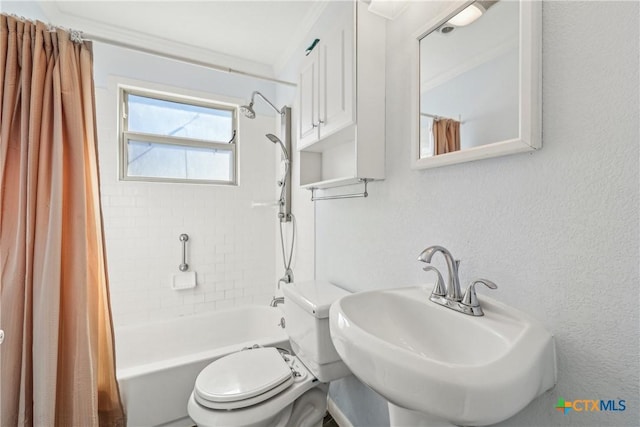 full bath with a textured wall, shower / bath combo, a sink, and toilet