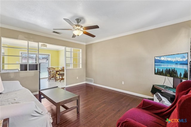 living room featuring baseboards, visible vents, wood finished floors, and ornamental molding