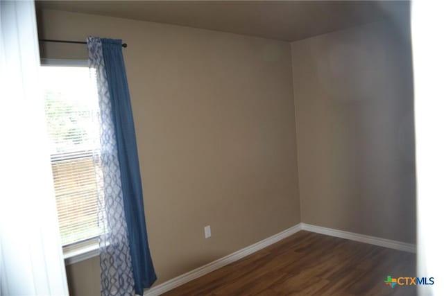 1204 N 18th St, Killeen, TX 76541 - empty room with dark wood-style flooring, plenty of natural light, and baseboards
