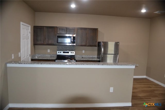 1204 N 18th St, Killeen, TX 76541 - kitchen with stainless steel appliances, dark brown cabinetry, baseboards, dark wood-style floors, and light stone counters