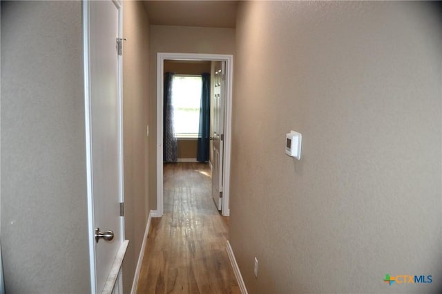 1204 N 18th St, Killeen, TX 76541 - corridor with wood finished floors, a textured wall, and baseboards