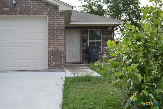 1204 N 18th St, Killeen, TX 76541 - entrance to property featuring brick siding, a garage, concrete driveway, and roof with shingles