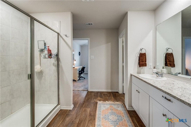 bathroom with vanity, wood-type flooring, and a shower with door