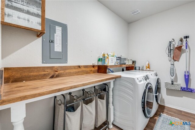 clothes washing area with electric panel, dark hardwood / wood-style floors, and independent washer and dryer