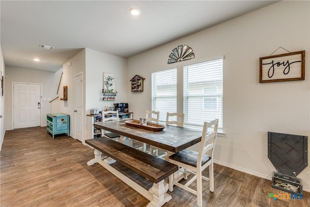 dining space with wood-type flooring