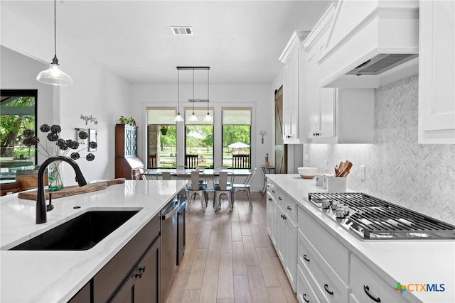 1306 Crystal Spgs, Salado, TX 76571 - kitchen with appliances with stainless steel finishes, custom range hood, a sink, backsplash, and white cabinets