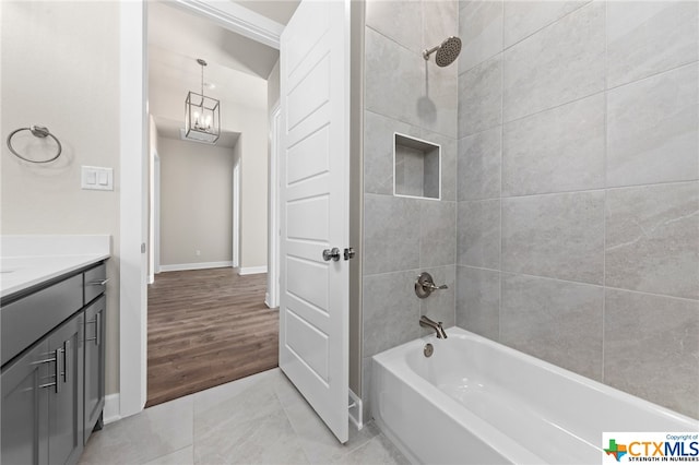 bathroom featuring tile patterned flooring, vanity, and tiled shower / bath