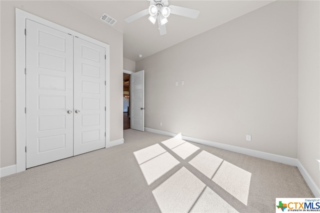 unfurnished bedroom featuring ceiling fan, light carpet, and a closet