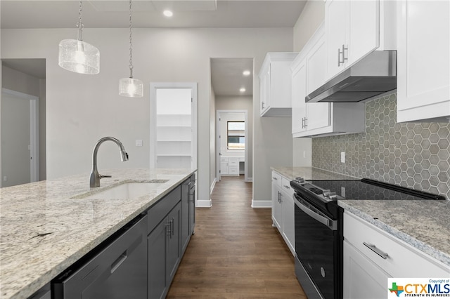 kitchen featuring white cabinetry, sink, stainless steel appliances, and decorative light fixtures