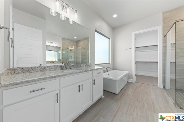 bathroom featuring hardwood / wood-style floors, vanity, and independent shower and bath