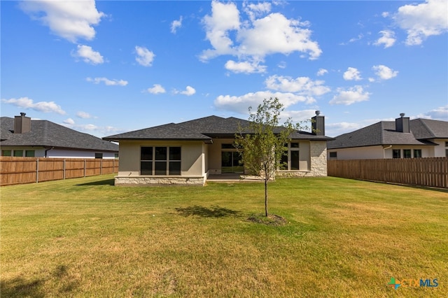 rear view of house featuring a lawn