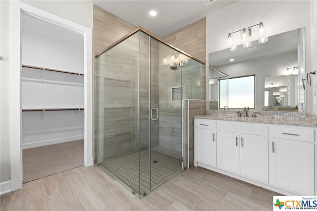 bathroom with vanity and a shower with shower door