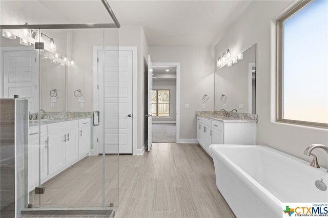 bathroom featuring hardwood / wood-style flooring, vanity, and shower with separate bathtub